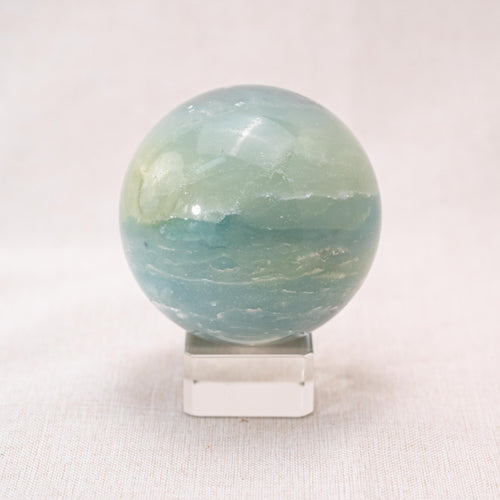 Amazonite sphere with turquoise-green color, used for healing and stress relief.