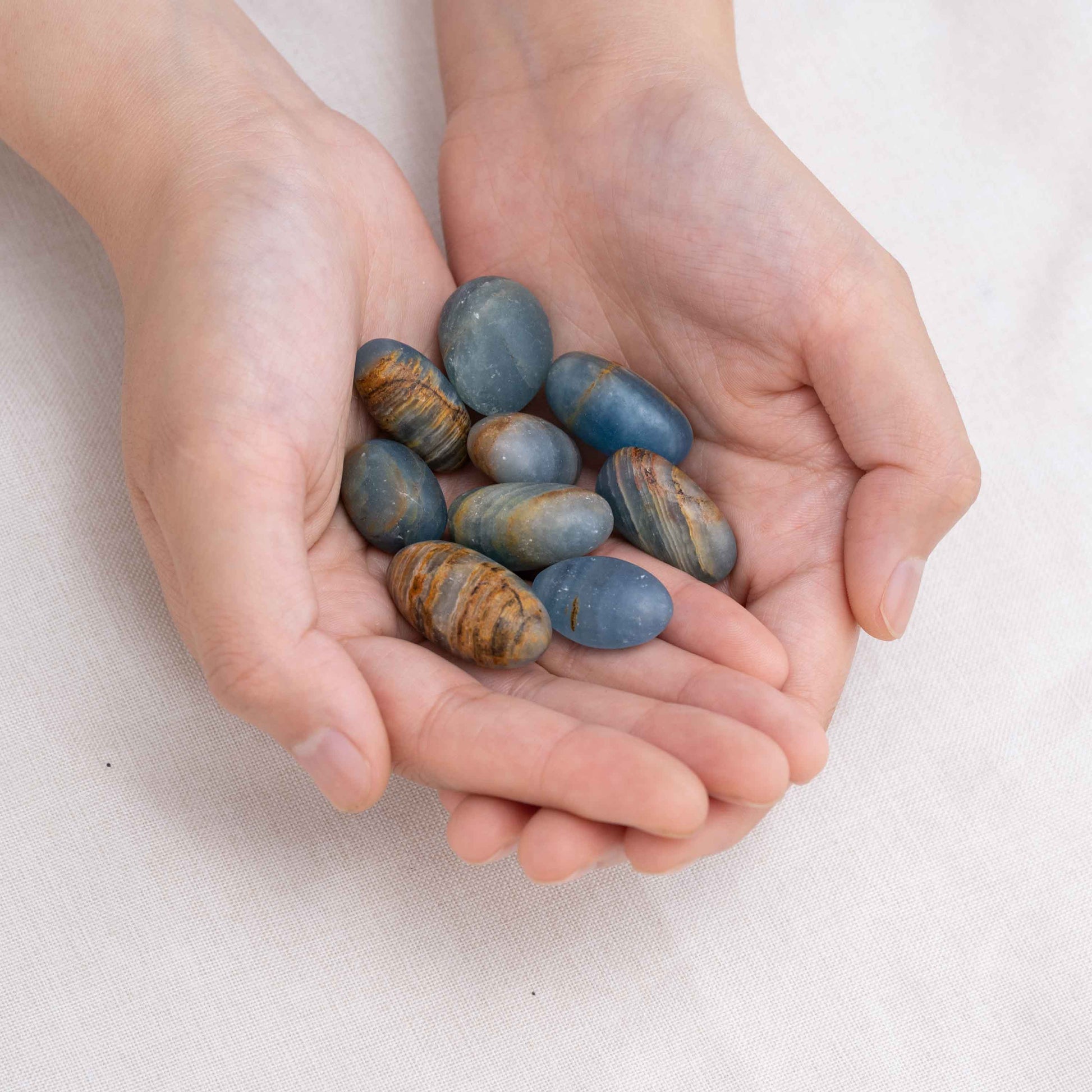 Hand cupping Blue Onyx tumbled stone for protection and grounding