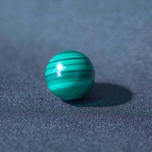 This Malachite Mini Sphere promotes healing and emotional balance with its vibrant green hues.