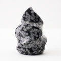 Natural Snowflake Obsidian Flame placed on a wooden surface for contrast