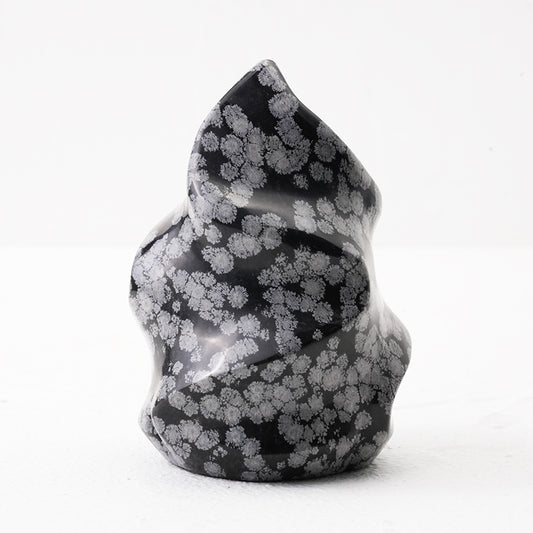 Natural Snowflake Obsidian Flame placed on a wooden surface for contrast